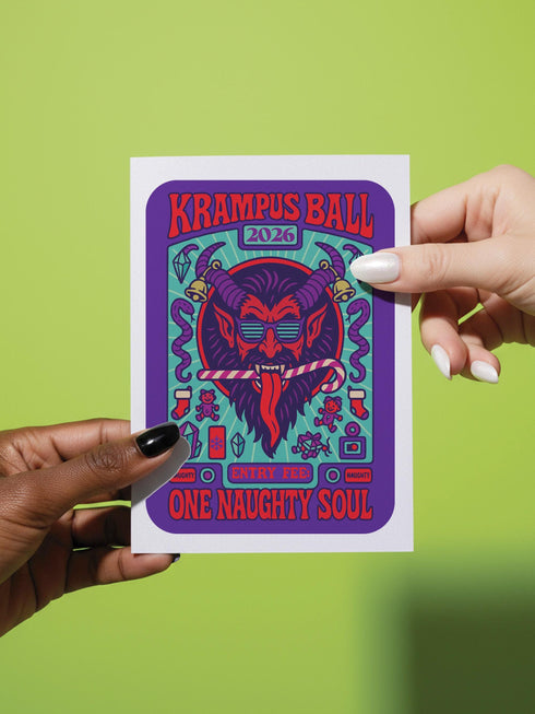 A vertical 5x7 inch folded greeting card featuring a detailed, psychedelic illustration of the folklore figure Krampus for a New Year celebration. The card stock has a shimmering pearlescent finish that reflects light, creating a glowing effect on the purple and teal artwork. The design mimics a vintage event poster reading "Krampus Ball 2026" and "Entry Fee: One Naughty Soul" in retro fonts. Krampus is depicted with large horns, sunglasses, and a long tongue holding a candy cane.