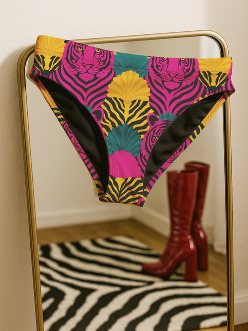 Tropical tiger print bikini bottom with vibrant pink, yellow, and teal psychedelic design. Mid-rise cut with cheeky coverage, double-layered fabric, UPF 50+, and soft, stretchy recycled polyester-spandex blend.