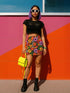 Honey Dazed retro floral mini skirt in a fitted pencil silhouette with high waist. Features a groovy all-over print of oversized flowers, checkers, waves, and bold 70s-inspired shapes in orange, red, purple, green, and yellow. Designed with a soft, sculpting stretch fabric for all-day comfort and drama. A statement piece made for maximalists, festival-goers, and vintage fashion freaks. Perfect for layering with puff sleeves and platform boots.