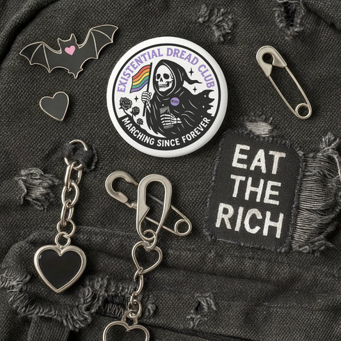 Round pinback button featuring a bold black and white design of a skeleton reaper holding a rainbow pride flag and a drink, wearing a "RESIST" badge, surrounded by black roses, with "Existential Dread Club" in purple letters and "Marching Since Forever" in white. Glossy, metal button in 2" or 3" size.
