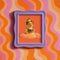 A vibrant fine art print of a rubber duck inspired by Frida Kahlo, complete with bold unibrow, floral crown, and traditional embroidered blouse. Framed in a red sculptural frame, the duck floats in orange-tinted bubbles against a deep orange backdrop and violet wall.