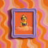 A vibrant fine art print of a rubber duck inspired by Frida Kahlo, complete with bold unibrow, floral crown, and traditional embroidered blouse. Framed in a red sculptural frame, the duck floats in orange-tinted bubbles against a deep orange backdrop and violet wall.