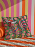 Square throw pillow cover with a printed faux embroidery design of a rooster wearing a white cowboy hat with red stars on a grass green background. The western chicken has a red comb and wattle, yellow beak and feet, and layered feathers in pink, green, orange, blue, and yellow with a rainbow striped tail. Pink and red flowers with yellow centers frame the bird. The stitched look is a flat 2D print on a smooth linen feel polyester cover with a hidden zipper, not raised embroidery.