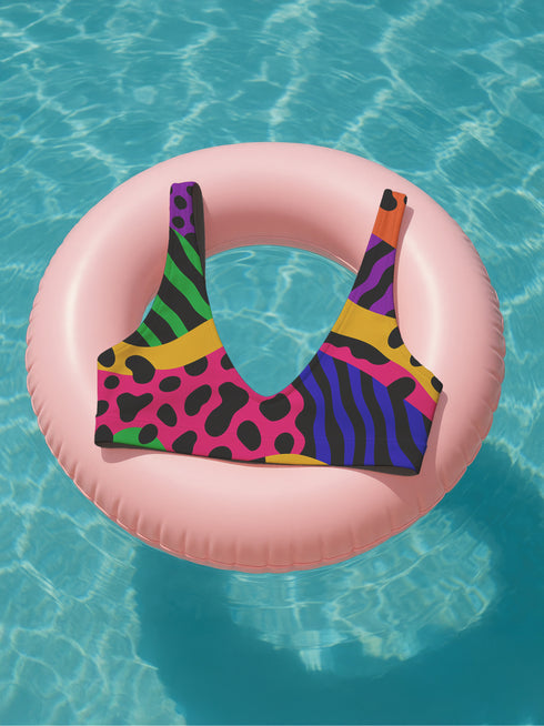Colorblock animal print bikini top with neon pink, orange, green, purple, and blue abstract pattern. Scoop neck cut with wide straps, removable padding, double-layered fabric, UPF 50+, and made from soft, stretchy recycled polyester-spandex blend.