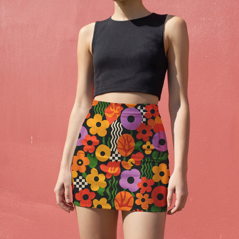 Honey Dazed retro floral mini skirt in a fitted pencil silhouette with high waist. Features a groovy all-over print of oversized flowers, checkers, waves, and bold 70s-inspired shapes in orange, red, purple, green, and yellow. Designed with a soft, sculpting stretch fabric for all-day comfort and drama. A statement piece made for maximalists, festival-goers, and vintage fashion freaks. Perfect for layering with puff sleeves and platform boots.