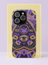 A matte finish phone case featuring a 2D optical illusion of a textured, purple crochet Ouija board planchette. The design includes intricate gold faux-embroidered borders, the words YES and NO, a central all-seeing eye, and a botanical leaf motif in the center circle. Lilac purple flowers and green leaves decorate the bottom half. The case has black rubber lining around the edges and camera cutouts. It looks like a thick, handmade yarn textile but is completely flat and smooth.