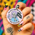 Honey Dazed Glossy round pink pinback button featuring a skeleton girl with purple hair holding a black flag that says “RESIST” and an energy drink can, with the phrases “No Rest for the Woke” and “Keep Resisting” in bold black letters.