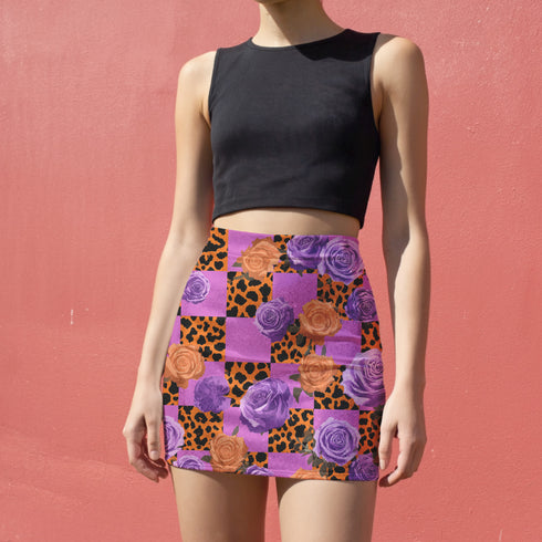 A woman wearing a black crop top and a colorful skirt with a floral pattern.