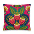 A square throw pillow with a vibrant, folk art-inspired design. The pillow's background is a bright, saturated fuchsia pink. The central design features four stylized strawberries arranged in a cluster, rendered in a way that mimics thick, textural embroidery. Each strawberry is red. The overall aesthetic is colorful, eclectic, and maximalist, with a distinct retro or 70s feel. The pillow cover has a visible linen-like texture.