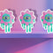 Trippy eyeball flower sticker in pastel pink and green, ideal for quirky and weirdcore enthusiasts. Available in Prism, Gem, and Glitter finishes. Handmade in Austin, Texas.