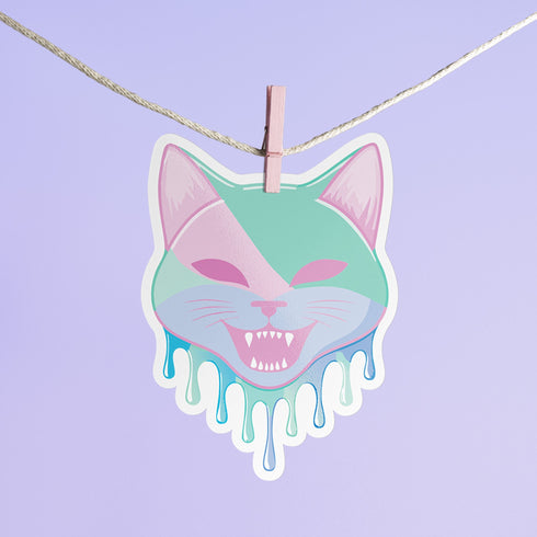 Adorable pastel kitty sticker with a cheeky fanged smile, perfect for adding a playful touch to your accessories. Available in Prism, Gem, and Glitter finishes. Handmade in Austin, Texas.