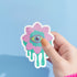 Trippy eyeball flower sticker in pastel pink and green, ideal for quirky and weirdcore enthusiasts. Available in Prism, Gem, and Glitter finishes. Handmade in Austin, Texas.