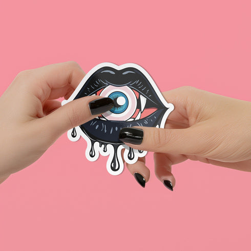 Eyeball vampire fangs sticker with black lips, perfect for adding a spooky touch to laptops, phones, and water bottles. Available in Prism, Gem, and Glitter finishes. Handmade in Austin, Texas.
