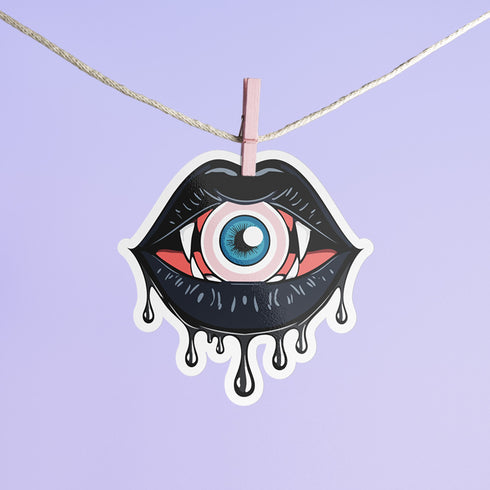 Eyeball vampire fangs sticker with black lips, perfect for adding a spooky touch to laptops, phones, and water bottles. Available in Prism, Gem, and Glitter finishes. Handmade in Austin, Texas.