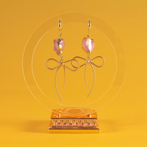 Earrings featuring pink rose quartz stones with 14k gold-plated brass bow designs, offering a sweet and sophisticated touch.