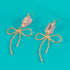 Earrings featuring pink rose quartz stones with 14k gold-plated brass bow designs, offering a sweet and sophisticated touch.