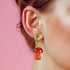 Handmade earrings featuring red agate mushroom-shaped drops with gold-plated caps, suspended from textured gold studs, showcasing unique cottagecore and boho aesthetic.