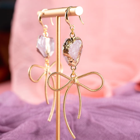 Earrings featuring pink rose quartz stones with 14k gold-plated brass bow designs, offering a sweet and sophisticated touch.