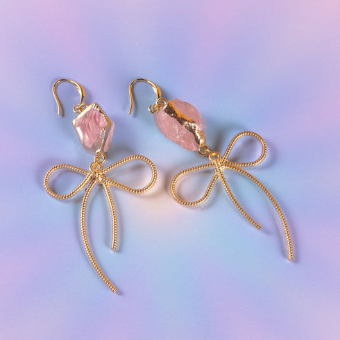 Earrings featuring pink rose quartz stones with 14k gold-plated brass bow designs, offering a sweet and sophisticated touch.