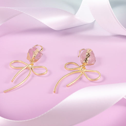 Earrings featuring pink rose quartz stones with 14k gold-plated brass bow designs, offering a sweet and sophisticated touch.
