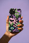 Dual layer phone case in matte or glossy with a 2D print that mimics thick crochet and yarn embroidery. Black bats, pink and green dripping slime, all-seeing eyes with lashes, purple and green daisies, and twisting pink and black checkered worms scatter across a black knit-look background. Smooth printed surface with no raised threads, open ports, and camera cutout. Pastel goth, creepy cute, whimsigoth, spooky maximalist phone accessory and gift.