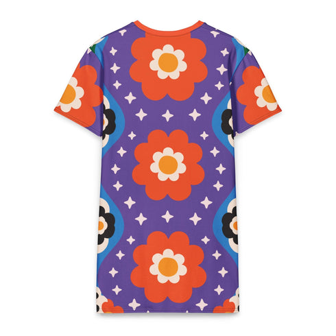 Short sleeve crew neck t-shirt dress in a relaxed, oversized straight cut, made of 100% polyester with a soft matte finish. An edge-to-edge all-over print on a medium purple background shows vertically stacked daisies with orange petals and yellow centers, scattered white four-point stars, and blue and green wavy side borders filled with small black and white daisies. Retro 70s floral, groovy maximalist alt fashion.