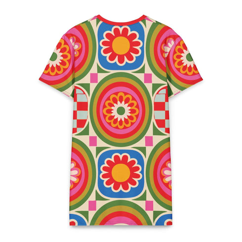 Short sleeve crew neck t-shirt dress in a relaxed, oversized straight cut, made of 100% polyester with a soft matte finish. An edge-to-edge all-over print on a cream background shows 60s daisies in red, yellow, and white set inside concentric rings of lime green, hot pink, orange, and royal blue, with magenta squares and red checkerboard accents. Retro 60s mod, flower power, rainbow maximalist alt fashion.