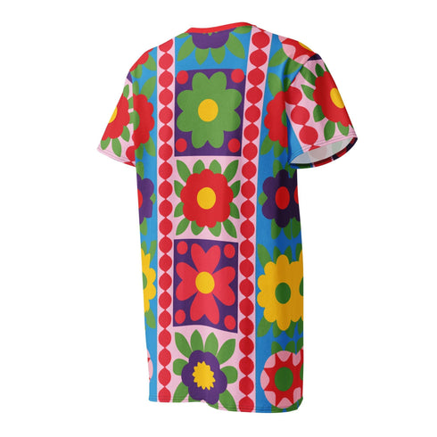 Short sleeve crew neck t-shirt dress in a relaxed, oversized straight cut, made of 100% polyester with a soft matte finish. An edge-to-edge all-over print shows 70s mod flowers in red, green, yellow, and purple set inside quilt-style patchwork panels of hot pink, royal blue, and lavender, divided by vertical stripes of red and pink polka dots. Retro 70s hippie, patchwork quilt, dopamine dressing maximalist alt fashion.