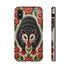 Dual layer matte phone case with a 2D print that mimics thick crewel embroidery. An angry black possum with a white face, bared sharp teeth, and bright red eyes and claws sits at the center on a cream background, framed by a symmetrical border of red folk art daisies with yellow centers and green leaves. Smooth printed surface with no raised threads, open ports, and a precise camera cutout. Goblincore, creepy cute, maximalist phone accessory.