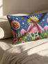 Rectangular 20 by 12 inch lumbar pillow cover printed to look like thick crewel embroidery on a deep royal blue night sky dotted with orange, yellow, and white stars. A silver, pink, and yellow flying saucer beams a bright pink cone of light onto a white cow with green spots standing in green grass with pine trees and red and pink flowers. Smooth flat 2D print, not raised stitching. Maximalist sci-fi decor for a bed, sofa, or reading nook.