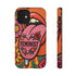 Dual layer matte phone case with a 2D print that mimics knit and embroidery texture. A retro open mouth with its tongue out sits over a pink heart stitched with the word FEMINIST in black letters, on an orange knit-look background filled with pink flowers, yellow sunflowers, red roses, purple and orange blooms, teal leaves, and a turquoise drip, all outlined in bold black. Smooth printed surface, open ports, camera cutout. Feminist maximalist phone accessory.