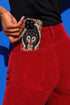 Dual layer matte phone case with a 2D print that mimics thick crewel embroidery. An angry black possum with a white face, bared sharp teeth, and bright red eyes and claws sits at the center on a cream background, framed by a symmetrical border of red folk art daisies with yellow centers and green leaves. Smooth printed surface with no raised threads, open ports, and a precise camera cutout. Goblincore, creepy cute, maximalist phone accessory.