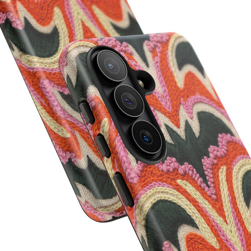 Dual layer matte phone case with a 2D print that mimics thick, heavy crochet yarn. Rows of stacked black bats repeat across a vibrant rust-orange background, accented with bright pink faux yarn bobbles and framed by cream arched lines. Smooth printed surface with no raised threads, open ports, and a precise camera cutout. Pastel goth, creepy cute, Summerween and Halloween phone accessory with a cozy handmade look.