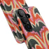 Dual layer matte phone case with a 2D print that mimics thick, heavy crochet yarn. Rows of stacked black bats repeat across a vibrant rust-orange background, accented with bright pink faux yarn bobbles and framed by cream arched lines. Smooth printed surface with no raised threads, open ports, and a precise camera cutout. Pastel goth, creepy cute, Summerween and Halloween phone accessory with a cozy handmade look.