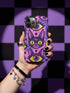 Dual layer matte phone case with a 2D print that mimics raised embroidery. Dark purple vampire bat cat heads with tall pointed ears, glowing chartreuse eyes, tiny fangs, and a pink crescent moon on the forehead repeat across a mottled purple and hot pink background, scattered with large chartreuse evil eyes with purple irises and small dark stars. Smooth printed surface with no raised threads, open ports, and camera cutout. Pastel goth, whimsigoth, creepy cute phone accessory.