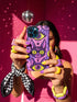 Dual layer matte phone case with a 2D print that mimics raised embroidery. Dark purple vampire bat cat heads with tall pointed ears, glowing chartreuse eyes, tiny fangs, and a pink crescent moon on the forehead repeat across a mottled purple and hot pink background, scattered with large chartreuse evil eyes with purple irises and small dark stars. Smooth printed surface with no raised threads, open ports, and camera cutout. Pastel goth, whimsigoth, creepy cute phone accessory.