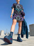 Short sleeve crew neck t-shirt dress in a relaxed, oversized straight cut, made of 100% polyester with a soft matte finish. An edge-to-edge all-over print on a black background shows ornate teal and grey damask scrollwork, purple roses with teal leaves, and a central evil eye framed by a decorative Victorian border and four-point stars. Gothic whimsigoth, dark romantic, witchy Victorian maximalist alt fashion.