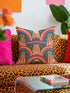 Square 70s psychedelic throw pillow cover printed to look like textured embroidery on a dark, starry navy background. Retro flying saucers and stylized alien eyes repeat across the design above rainbow arches, with small yellow stars and beams of light. Smooth flat 2D print, not raised stitching. Trippy, groovy, retro space age maximalist decor for a sofa, dorm bed, or reading nook, made for sci-fi fans and alien lovers.