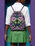 Drawstring backpack measuring 15 by 17 inches, made of 100% polyester with narrow shoulder straps and a drawstring closure. A symmetrical pastel goth print of bats, stylized eyes, flowers, and stars in a soft pastel palette sits on a black base, framed by purple and green checkerboard bands. Creepy cute, whimsigoth, kawaii goth style bag made for the gym, concerts, festivals, travel, school, and everyday carry.