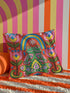 Square folk art throw pillow cover printed to look like textured crewel embroidery on a coral orange background. A green frog sits cross-legged in a meditation pose beneath a blue and yellow arch, surrounded by symmetrical pink flowers. Smooth flat 2D print, not raised stitching. Colorful, whimsical, maximalist dopamine decor for a yoga room, meditation corner, sofa, or reading nook, made for yoga lovers and frog fans.