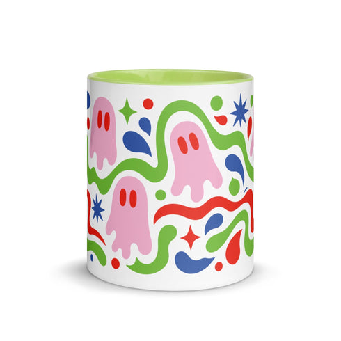 Glossy white ceramic 11 oz coffee mug with a lime green rim, inside, and handle and a full wraparound pastel goth print. Pink ghosts with paired red oval eyes and rounded scalloped lower edges float between wavy green and red ribbons. Blue starbursts, curved blue shapes, red teardrops, small colorful dots, and green diamond sparkles fill the white background. Creepy cute Halloween coffee mug with a playful, retro maximalist feel.