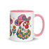 Glossy white ceramic coffee mug with a colored rim, inside, and handle and a full wraparound folk art print. Chickens wear pink cowboy hats with teal bands, yellow diamonds, flowers, and teardrop motifs. The birds have white heads, red combs and wattles, and layered pink, teal, and golden yellow feathers outlined in black. Pink and yellow flowers, teal leaves, and four-point starbursts fill the space between. Retro western kitchen decor.