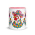Glossy white ceramic coffee mug with a colored rim, inside, and handle and a full wraparound folk art print. Chickens wear pink cowboy hats with teal bands, yellow diamonds, flowers, and teardrop motifs. The birds have white heads, red combs and wattles, and layered pink, teal, and golden yellow feathers outlined in black. Pink and yellow flowers, teal leaves, and four-point starbursts fill the space between. Retro western kitchen decor.