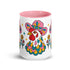 Glossy white ceramic coffee mug with a colored rim, inside, and handle and a full wraparound folk art print. Chickens wear pink cowboy hats with teal bands, yellow diamonds, flowers, and teardrop motifs. The birds have white heads, red combs and wattles, and layered pink, teal, and golden yellow feathers outlined in black. Pink and yellow flowers, teal leaves, and four-point starbursts fill the space between. Retro western kitchen decor.