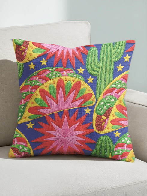 Square maximalist throw pillow cover printed to look like bold crewel embroidery on a solid royal blue background. Tacos with green, red, and brown fillings scatter across the design with bright green saguaro cacti, large pink and red starburst flowers, and small yellow stars. Smooth flat 2D print, not raised stitching. Colorful, quirky dopamine decor for a sofa, kitchen bench, or breakfast nook, made for taco lovers and foodies.