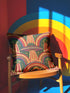 Square 70s psychedelic throw pillow cover printed to look like textured embroidery on a dark, starry navy background. Retro flying saucers and stylized alien eyes repeat across the design above rainbow arches, with small yellow stars and beams of light. Smooth flat 2D print, not raised stitching. Trippy, groovy, retro space age maximalist decor for a sofa, dorm bed, or reading nook, made for sci-fi fans and alien lovers.