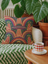 Square 70s psychedelic throw pillow cover printed to look like textured embroidery on a dark, starry navy background. Retro flying saucers and stylized alien eyes repeat across the design above rainbow arches, with small yellow stars and beams of light. Smooth flat 2D print, not raised stitching. Trippy, groovy, retro space age maximalist decor for a sofa, dorm bed, or reading nook, made for sci-fi fans and alien lovers.