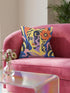 Square eclectic throw pillow cover with a surreal modern art portrait printed to look like textured crewel embroidery on a cobalt blue background. A yellow and purple half face with red lips holds a yellow crescent moon and a pink and purple staircase inside its dark silhouette, with a large orange flower in wavy yellow hair and abstract pink and yellow shapes around it. Smooth flat 2D print, not raised stitching. Maximalist art decor for a sofa, studio chair, or dorm.