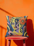 Square eclectic throw pillow cover with a surreal modern art portrait printed to look like textured crewel embroidery on a cobalt blue background. A yellow and purple half face with red lips holds a yellow crescent moon and a pink and purple staircase inside its dark silhouette, with a large orange flower in wavy yellow hair and abstract pink and yellow shapes around it. Smooth flat 2D print, not raised stitching. Maximalist art decor for a sofa, studio chair, or dorm.