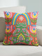 Square folk art throw pillow cover printed to look like textured crewel embroidery on a coral orange background. A green frog sits cross-legged in a meditation pose beneath a blue and yellow arch, surrounded by symmetrical pink flowers. Smooth flat 2D print, not raised stitching. Colorful, whimsical, maximalist dopamine decor for a yoga room, meditation corner, sofa, or reading nook, made for yoga lovers and frog fans.